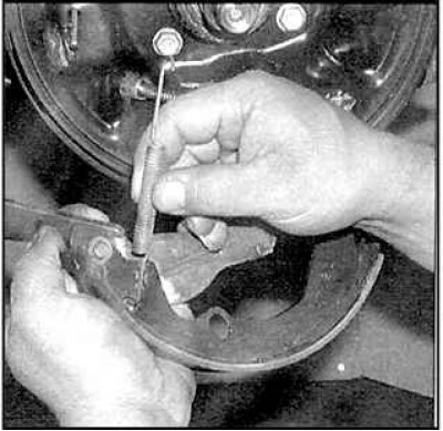 8. Снимите прижимную пружину задней тормозной колодки.