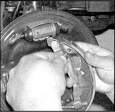 9. Снимите заднюю тормозную колодку и отсоедините возвратную пружину.