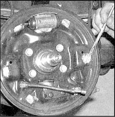 12. Снимите тросик ручного тормоза от рычага на задней тормозной колодке.