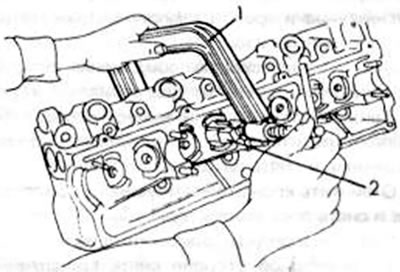 Рис. 41. Снятие клапанов с помощью съемника. 1. Струбцина; 2. Нажимной пуансон