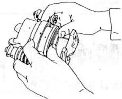 Рис.222. При сборке цилиндра суппорта тормоза поршень, как показано, надавить большими пальцами.