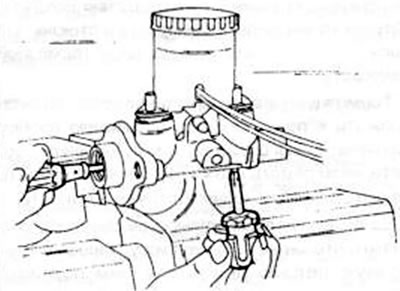 Рис. 239. Освобождение стопорного болта на нижней стороне главного тормозного цилиндра