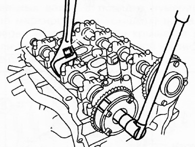 18. Држећи брегасту осовину за шестоугаони део помоћу подесивог кључа, одврните завртње који…