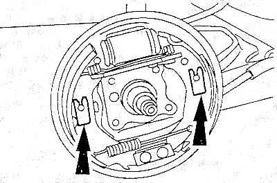 Отжать две пружины крепления тормозных колодок вниз отверткой.